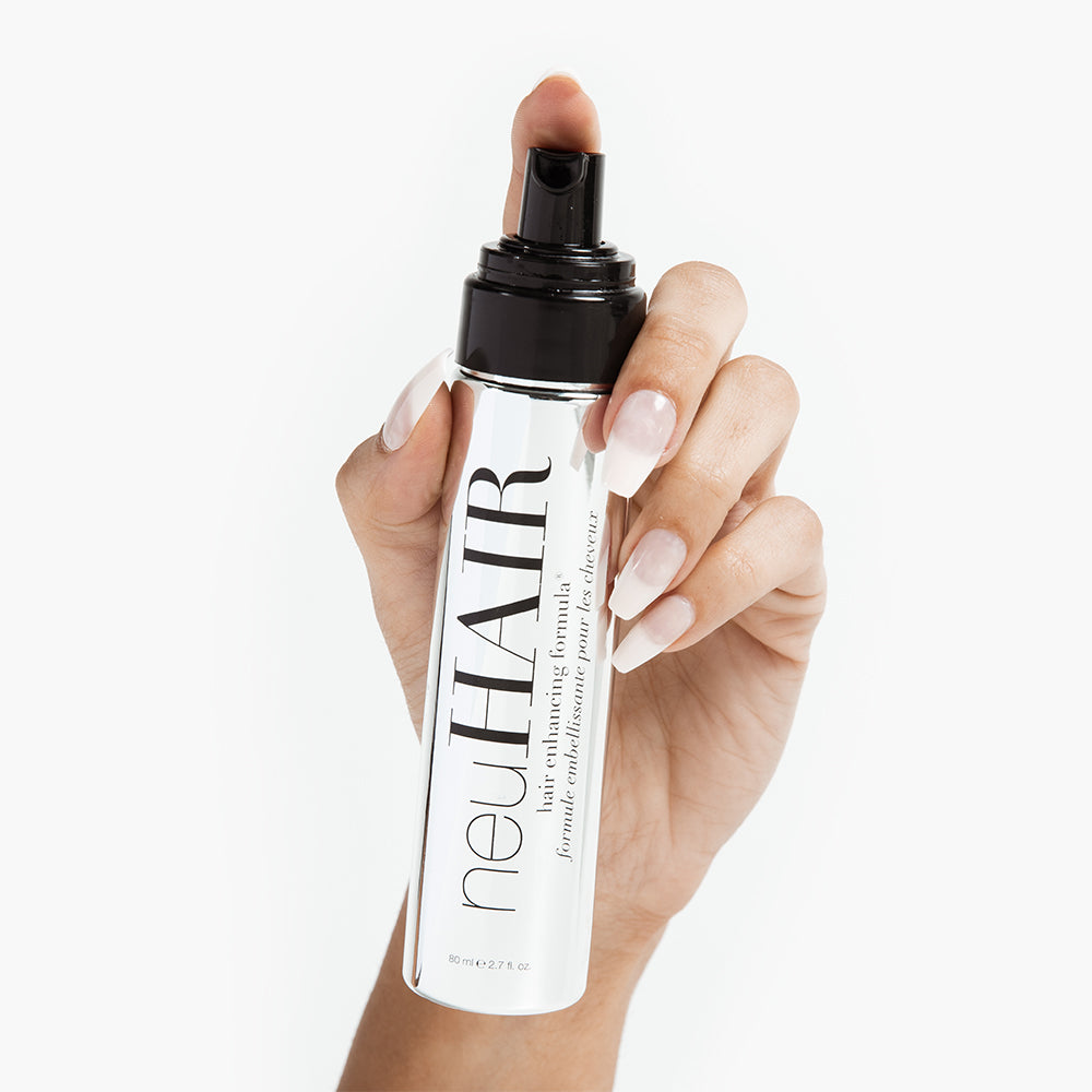 neuHair product held by a model's hand